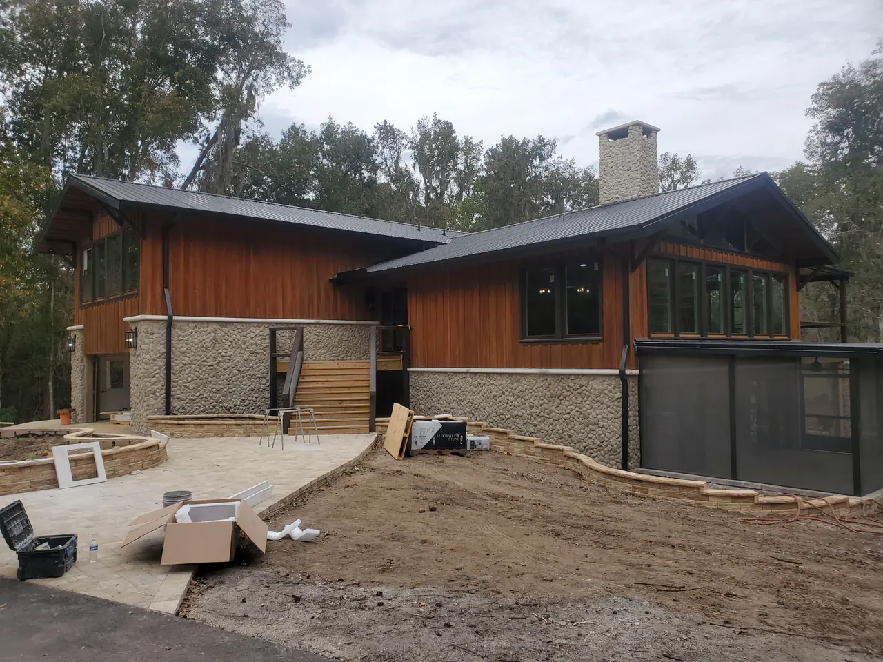 Wood cladding and dark-framed windows above the stone exterior.